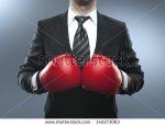 stock-photo-businessman-in-boxing-gloves-isolated-on-blue-142273063
